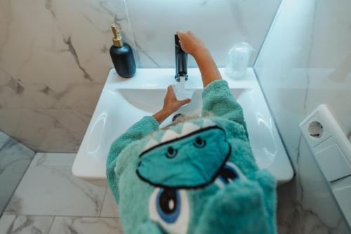 a toy frog is playing with a faucet in a bathroom at Hotel Janssen in Valkenburg