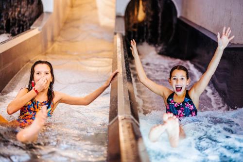 two girls playing in a water slide at Thermenhotel Karawankenhof in Villach