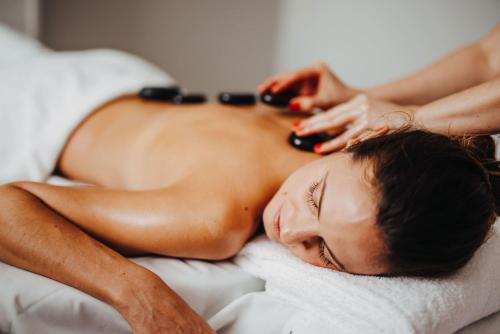 a woman laying on a bed getting a massage at Thermenhotel Karawankenhof in Villach