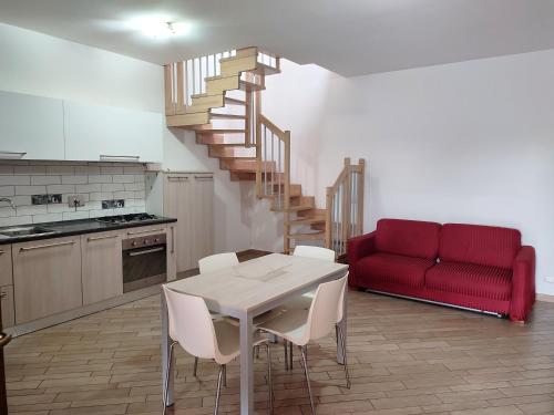 a living room with a table and a red couch at Country Love Dragona House tra mare e città in Acilia