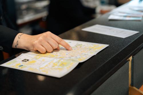 a hand points to a map on a table at Hotel Minerva in Arezzo