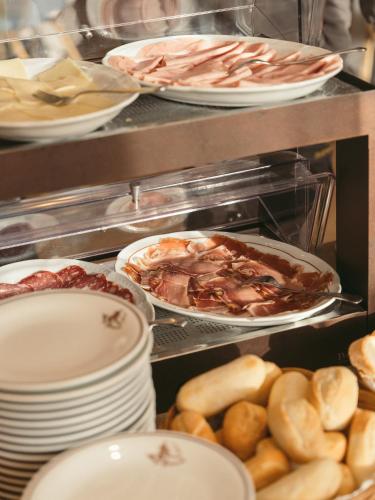 a buffet with plates of food and other foods at Hotel Minerva in Arezzo
