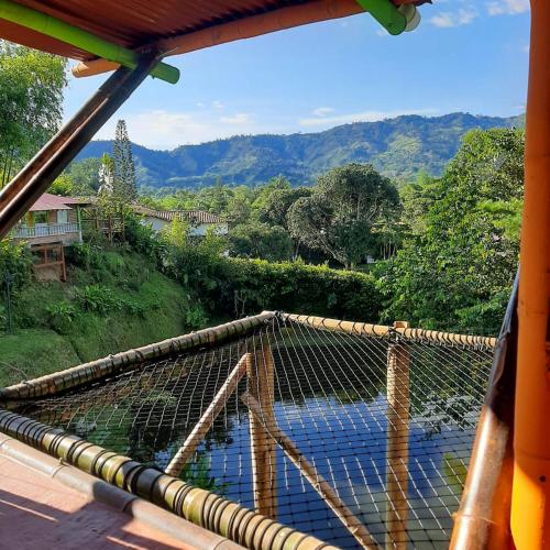 a balcony with a view of a river and mountains at Cabaa Type Glamping - with swimming pool in Rizaralda