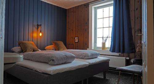 two beds in a room with a window at Krossbu in Boverdalen