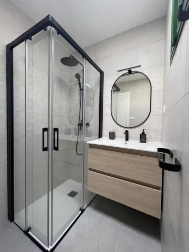 a bathroom with a shower and a sink and a mirror at Charming bungalow with private garden in Maspalomas