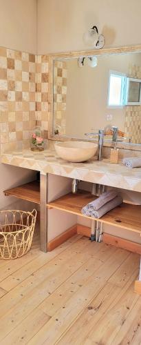 une salle de bain avec un lavabo et un grand miroir dans l'établissement Villa Maélie, à Uzès
