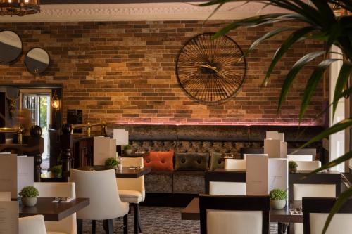 a restaurant with a brick wall and tables and chairs at The Devon Hotel in Exeter