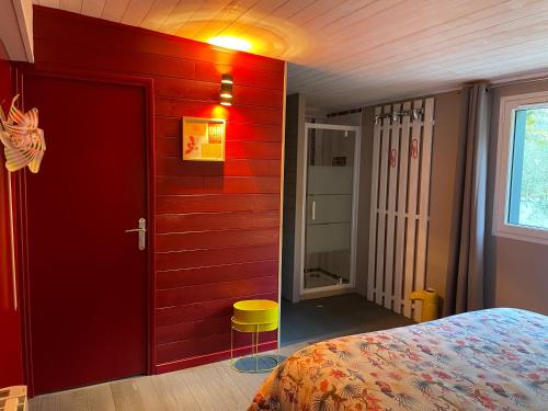Pluherlin的住宿－Magnifique villa avec jacuzzi，卧室设有红色的门和黄色凳子