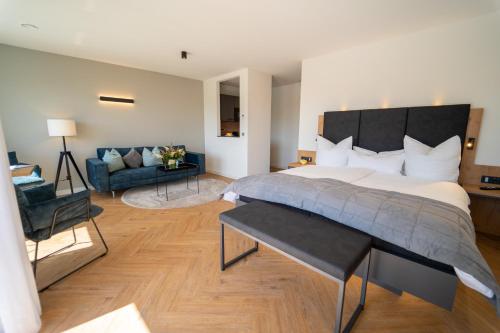 a bedroom with a large bed and a couch at Hotel Zur Traube in Ürzig