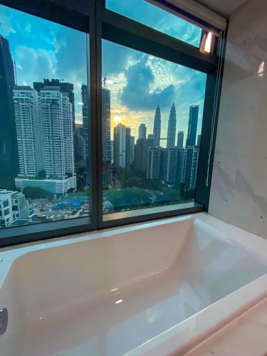 a bath tub with a view of the city at Eaton Residence KLCC in Kuala Lumpur