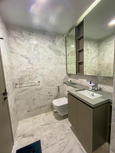 a bathroom with a toilet and a sink and a mirror at Eaton Residence KLCC in Kuala Lumpur