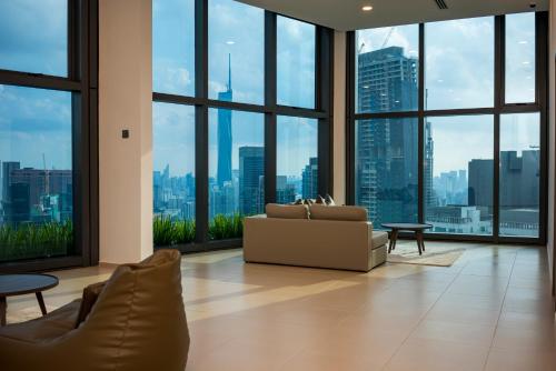 a living room with a couch and large windows at Eaton Residence KLCC in Kuala Lumpur