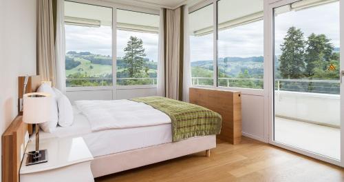 A bed or beds in a room at Oberwaid - Das Hotel.