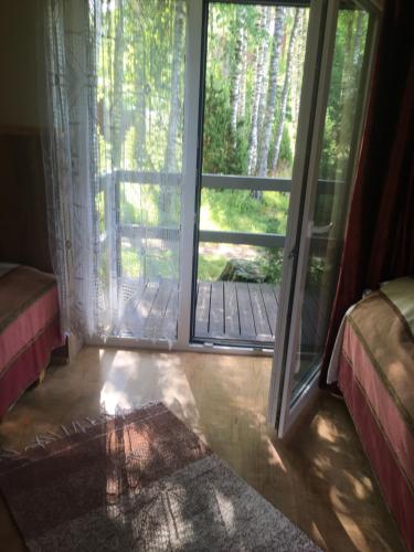 a room with a sliding glass door with a deck at Voosemetsa Turismitalu in Voose