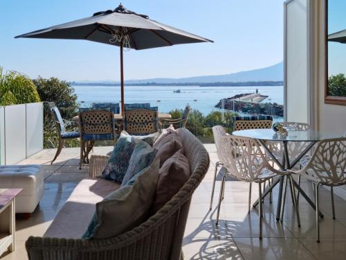 a living room with a couch and a table with an umbrella at 'The View' on Bikini Beach, Seafront, 2 bedroom, Sleeps 4 in Gordonʼs Bay