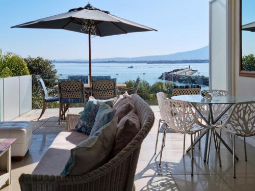 a living room with a couch and a table with an umbrella at The View on Bikini Beach, Sleeps 4 in Gordonʼs Bay