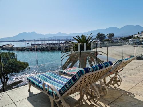 a couple of lounge chairs sitting on top of a beach at 'The View' on Bikini Beach, Seafront, 2 bedroom, Sleeps 4 in Gordonʼs Bay