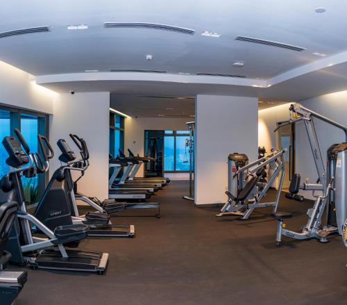 a gym with a row of treadmills and machines at Eaton Residence KLCC in Kuala Lumpur