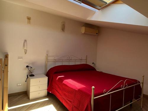 una camera con un letto con una coperta rossa di Country Love Dragona House tra mare e città ad Acilia