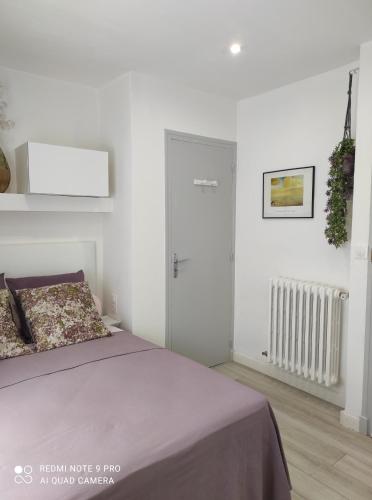 a white bedroom with a bed and a white door at Chambre accueillante à 2 mn du centre ville in Perpignan