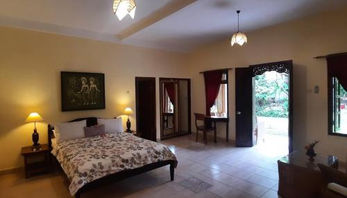 a bedroom with a bed and a table in it at Rambutan Hotel in Lovina