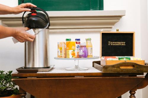 a person holding a kettle on top of a table at Domus Socolatae Residenza d'Epoca Charming B&B - Adults Only in Follonica