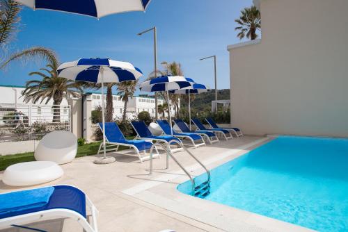 a beach area with umbrellas, chairs, and tables at Hotel Nautilus in Cagliari