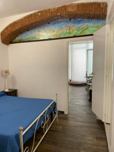 1 dormitorio con 1 cama y una pintura en la pared en B&B bottega 11, en Burchio
