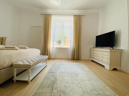 a bedroom with a bed and a tv and a window at Suite № 7 in Braşov