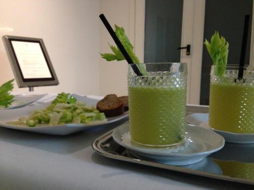 a table with two glasses of green juice and a plate of food at Hotel Mamiani & Relaxing Spa Urbino in Urbino