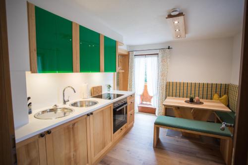 une cuisine avec deux lavabos et des armoires vertes dans l'établissement Gästehaus Göllblick, à Bischofswiesen