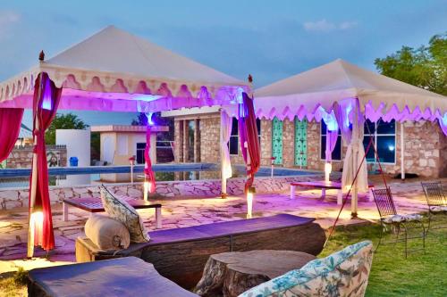 a tent with tables and chairs in front of a pool at Shivohum Adventure Retreat in Sāmod