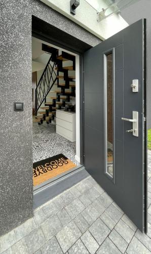 an open door to a house with a staircase at Domy na Roztoczu Aleja Lipowa Dom F in Zwierzyniec