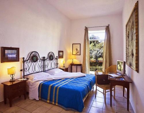a bedroom with a bed and a desk and a window at Hotel Villa Maria in Ischia