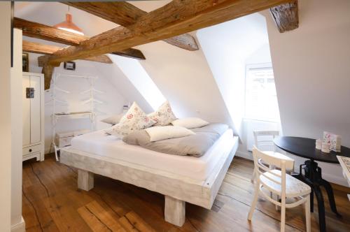 ein weißes Bett in einem Zimmer mit Holzböden in der Unterkunft Schlafstube Bamberg in Bamberg