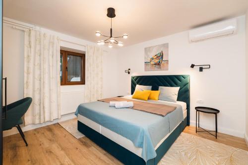 a bedroom with a bed and a chair in it at Amfora Maris Apartment in Split