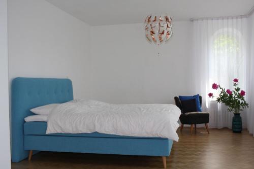 1 dormitorio con 1 cama azul y 1 silla azul en Das Blaue Haus - Ferienwohnung Schönherr en Kassel