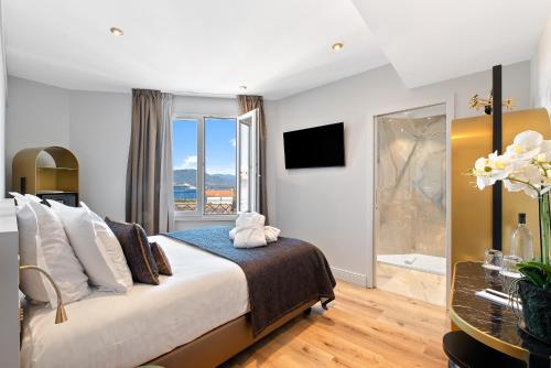 a bedroom with a large bed and a bathroom at Hotel San Carlu Citadelle Ajaccio in Ajaccio