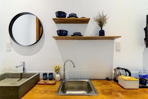 a kitchen with a sink and a mirror on the wall at Leaf Signature Hotel - Lá Group in Ho Chi Minh City