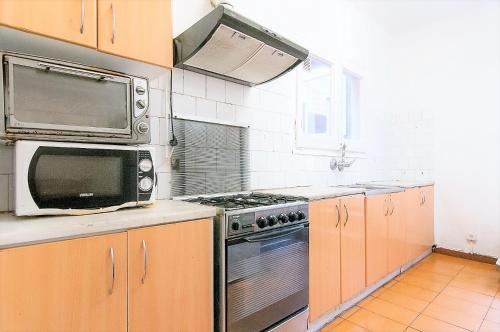a kitchen with a microwave and a stove at Pintor Pahissa Rooms in Barcelona