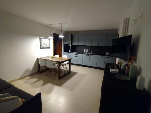 a living room with a table and a kitchen at Appartamento Dellantonio in Predazzo