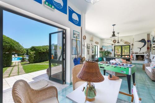 a living room with a glass door and a game table at Residence Punta Cassano - In piscina sulla spiaggia di sabbia in San Foca