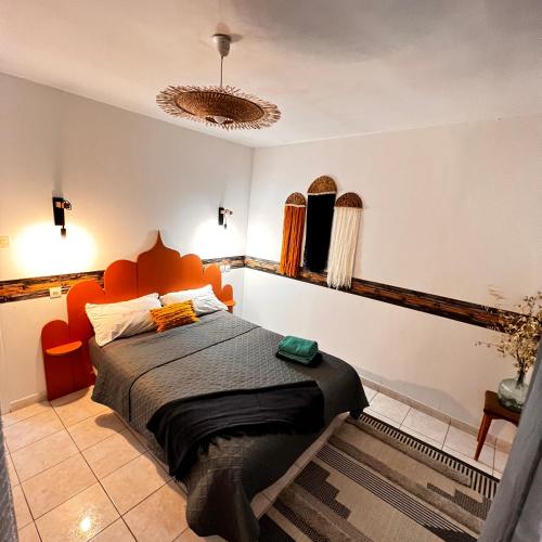 - une chambre avec un lit doté d'une tête de lit orange dans l'établissement Ancien corps de ferme 3 chambres avec spa, à Narbonne