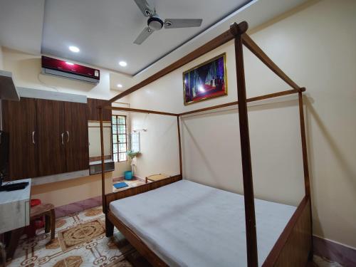 ein Schlafzimmer mit einem Himmelbett und einem TV an der Wand in der Unterkunft Monalisa Lodge in Vishnupur