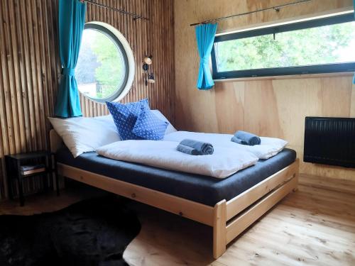 łóżko w pokoju z niebieskimi zasłonami i oknem w obiekcie Chata NEMO w mieście Hlinsko