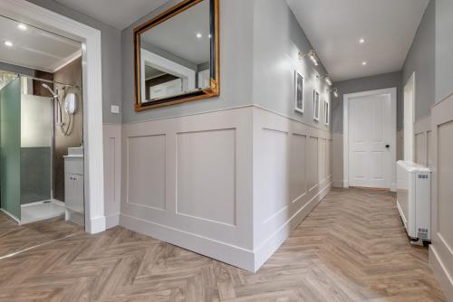 a hallway with a mirror on a wall at The Doctor's House Central with Street Parking in St. Andrews