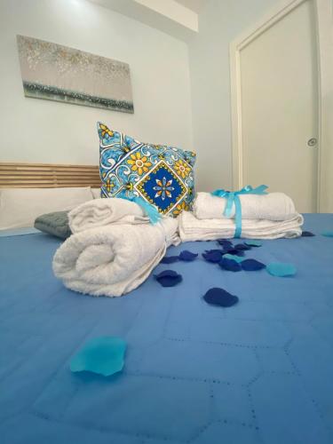 - une chambre avec des serviettes et des oreillers sur un lit dans l'établissement Casa Nanà, à Pouzzoles