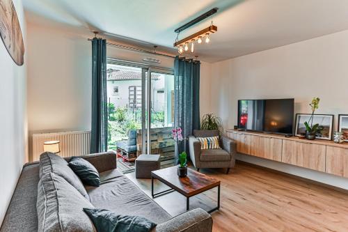 un salon avec un canapé et une télévision dans l'établissement Atlantic Selection - Le Galupat - Au calme avec jardin & parking, à Capbreton