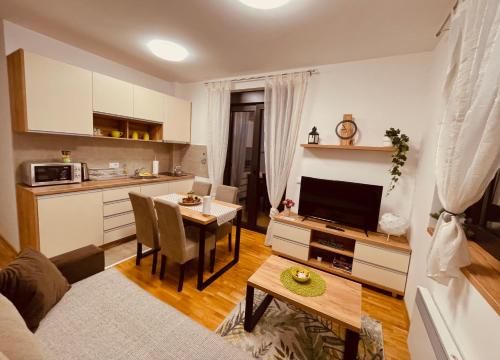 een woonkamer met een keuken en een eetkamer bij Lux Apartmani Vojinović in Zlatibor