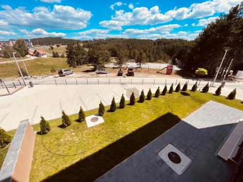un parque con una línea de árboles y césped en Apartmani Vojinović, en Zlatibor